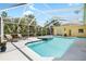 A screened-in pool and hot tub feature two lounge chairs with bright, light-blue water at 2513 Regal River Rd, Valrico, FL 33596