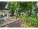 Lush backyard featuring tropical plants, mature trees, gravel area and a view of the screened patio at 2525 Madrid S Way, St Petersburg, FL 33712