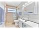 This bathroom has a tile shower and a sleek, modern vanity with a glass countertop and ample storage at 2525 Madrid S Way, St Petersburg, FL 33712