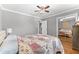 This bedroom has hardwood floors, neutral grey walls, a ceiling fan, and direct access to a mirrored closet at 2525 Madrid S Way, St Petersburg, FL 33712