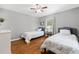 This bedroom is furnished with two twin beds, hardwood floors, neutral grey walls, and a ceiling fan at 2525 Madrid S Way, St Petersburg, FL 33712