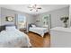 This bedroom is furnished with two twin beds, hardwood floors, neutral grey walls, and two large windows at 2525 Madrid S Way, St Petersburg, FL 33712