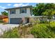 Charming two-story home featuring a gray paved driveway, attached garage, and well-manicured landscaping at 2525 Madrid S Way, St Petersburg, FL 33712