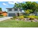 Attractive two-story home with a paved driveway and tropical landscaping enhancing its curb appeal at 2525 Madrid S Way, St Petersburg, FL 33712