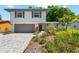 Charming two-story home featuring a gray paved driveway, attached garage, and well-manicured landscaping at 2525 Madrid S Way, St Petersburg, FL 33712
