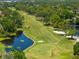 Beautiful view of golf course featuring green fairways, a scenic pond, sand traps, and golfers at 2525 Madrid S Way, St Petersburg, FL 33712