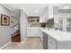Well-lit kitchen featuring white cabinets, stainless steel appliances, and access to the stairwell at 2525 Madrid S Way, St Petersburg, FL 33712