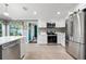 Open concept kitchen with stainless steel appliances, tiled backsplash, and access to dining and sitting rooms at 2525 Madrid S Way, St Petersburg, FL 33712