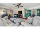 Bright living room with couches, chairs, and floral ottomans and view to stairs and dining room at 2525 Madrid S Way, St Petersburg, FL 33712