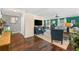 Cozy living room with dark-stained floors, a media center, an accent wall, and contemporary furnishings at 2525 Madrid S Way, St Petersburg, FL 33712