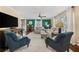 Comfortable living room with sofas, chairs, large windows, and green accent wall at 2525 Madrid S Way, St Petersburg, FL 33712