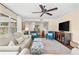 Inviting living room with bright furnishings, a fan, and an area rug with view to stairs at 2525 Madrid S Way, St Petersburg, FL 33712