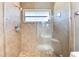 The tiled walk-in shower features a glass door and updated fixtures for a modern and luxurious feel at 2525 Madrid S Way, St Petersburg, FL 33712