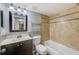 Bathroom featuring dark vanity, mosaic backsplash, tiled shower and tub combination at 2690 Coral Landings Blvd # 122, Palm Harbor, FL 34684
