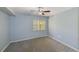 Bedroom with blue walls, ceiling fan, neutral carpeting, and a window at 2690 Coral Landings Blvd # 122, Palm Harbor, FL 34684