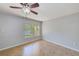 Bedroom featuring tile floors, a ceiling fan, and a sunlit window overlooking the water at 2690 Coral Landings Blvd # 122, Palm Harbor, FL 34684