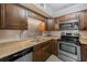 Modern kitchen featuring stainless steel appliances, wooden cabinets, and stone countertops at 2690 Coral Landings Blvd # 122, Palm Harbor, FL 34684