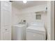 Bright laundry room with washer, dryer, wire shelving, and door to access at 2690 Coral Landings Blvd # 122, Palm Harbor, FL 34684
