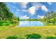 A beautiful pond featuring fountain, green grass, and trees at 2690 Coral Landings Blvd # 122, Palm Harbor, FL 34684
