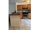 Well-lit kitchen with wooden cabinets, stainless steel appliances, and a tiled floor at 2961 Flint N Dr, Clearwater, FL 33759