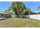 A spacious backyard featuring a screened lanai with a pool and a well-maintained lawn surrounded by white fencing at 3041 Avalon Terrace Dr, Valrico, FL 33596