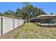 A backyard featuring a new white fence, bordering a lawn with a pool, and providing a secure and private outdoor space at 3041 Avalon Terrace Dr, Valrico, FL 33596