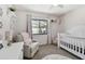 This bedroom features a window view to a pool, complemented by a cozy chair and a crib at 3041 Avalon Terrace Dr, Valrico, FL 33596