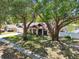 A charming home is framed by mature trees with a well-manicured lawn and an attached two-car garage at 3041 Avalon Terrace Dr, Valrico, FL 33596