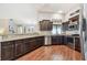 Spacious kitchen with stainless steel appliances, dark cabinets, granite countertops and wood floors at 3041 Avalon Terrace Dr, Valrico, FL 33596