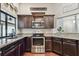 Well-equipped kitchen featuring dark cabinets, granite countertops, and stainless steel appliances at 3041 Avalon Terrace Dr, Valrico, FL 33596