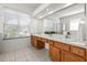Bright bathroom featuring double sinks, tiled floors, and a glass-enclosed shower at 3119 Bent Creek Dr, Valrico, FL 33596