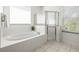 Well-lit bathroom with a soaking tub and glass-enclosed shower at 3119 Bent Creek Dr, Valrico, FL 33596