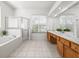 Bright bathroom featuring double sinks, tiled floors, and a glass-enclosed shower at 3119 Bent Creek Dr, Valrico, FL 33596