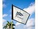 Close-up of a golf course flag with the 'River Hills' logo waving in the wind against a blue sky at 3119 Bent Creek Dr, Valrico, FL 33596