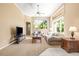 This sun-lit living room features plush seating, a ceiling fan, and large windows overlooking the landscaped backyard at 3119 Bent Creek Dr, Valrico, FL 33596