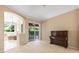 Open living area with neutral colors, a dark wood piano, and sliding door to the outdoor patio at 3119 Bent Creek Dr, Valrico, FL 33596