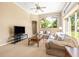 Bright living room featuring neutral walls, a ceiling fan, and large windows overlooking the landscaped backyard at 3119 Bent Creek Dr, Valrico, FL 33596