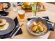 Delicious food is plated on a wood table with drinks and place settings in this dining area at 3119 Bent Creek Dr, Valrico, FL 33596