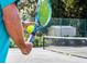 Tennis player holding a ball and racket on a well-maintained court, ready to serve in a recreational setting at 3119 Bent Creek Dr, Valrico, FL 33596