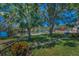 A spacious lawn leads to a waterfront view with a dock and lush greenery in this home's backyard at 3133 Pineview Dr, Holiday, FL 34691
