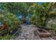 Expansive brick patio with a built-in fire pit and lush landscaping at 3133 Pineview Dr, Holiday, FL 34691