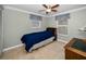 Cozy bedroom featuring tile floors, a ceiling fan, and natural light from the window at 3133 Pineview Dr, Holiday, FL 34691