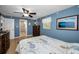 Bedroom featuring a bed, ceiling fan, light blue walls, and bathroom access at 3133 Pineview Dr, Holiday, FL 34691