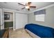 Bedroom features tile floors, a closet with sliding doors, and a ceiling fan at 3133 Pineview Dr, Holiday, FL 34691