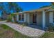 Charming front entrance with brick walkway, lush landscaping, and a welcoming dark wood door at 3133 Pineview Dr, Holiday, FL 34691