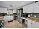 Well-equipped kitchen with stainless steel appliances, white cabinets, and neutral countertops at 3133 Pineview Dr, Holiday, FL 34691