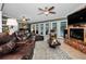 Inviting living room featuring a fireplace, ceiling fans, and patio doors overlooking the pool area at 3133 Pineview Dr, Holiday, FL 34691