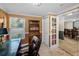 Office space with built-in bookshelves, a large window, and adjacent dining area at 3133 Pineview Dr, Holiday, FL 34691