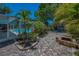 Charming brick patio with a fire pit and view of the screened-in pool at 3133 Pineview Dr, Holiday, FL 34691