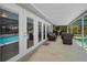Covered patio with outdoor seating, overlooking a sparkling swimming pool at 3133 Pineview Dr, Holiday, FL 34691